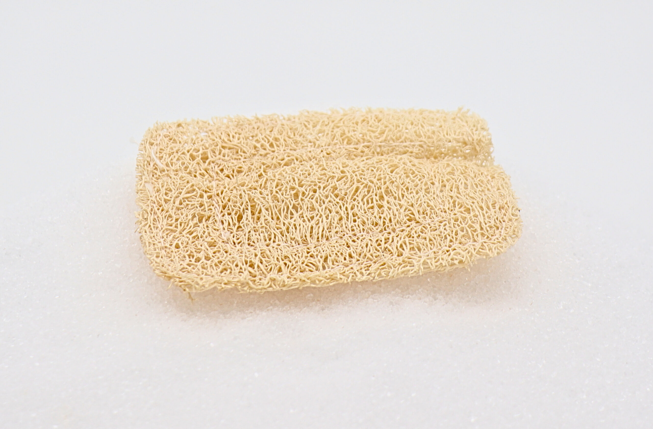 Luffa-Seifenkissen a loofah on a white surface