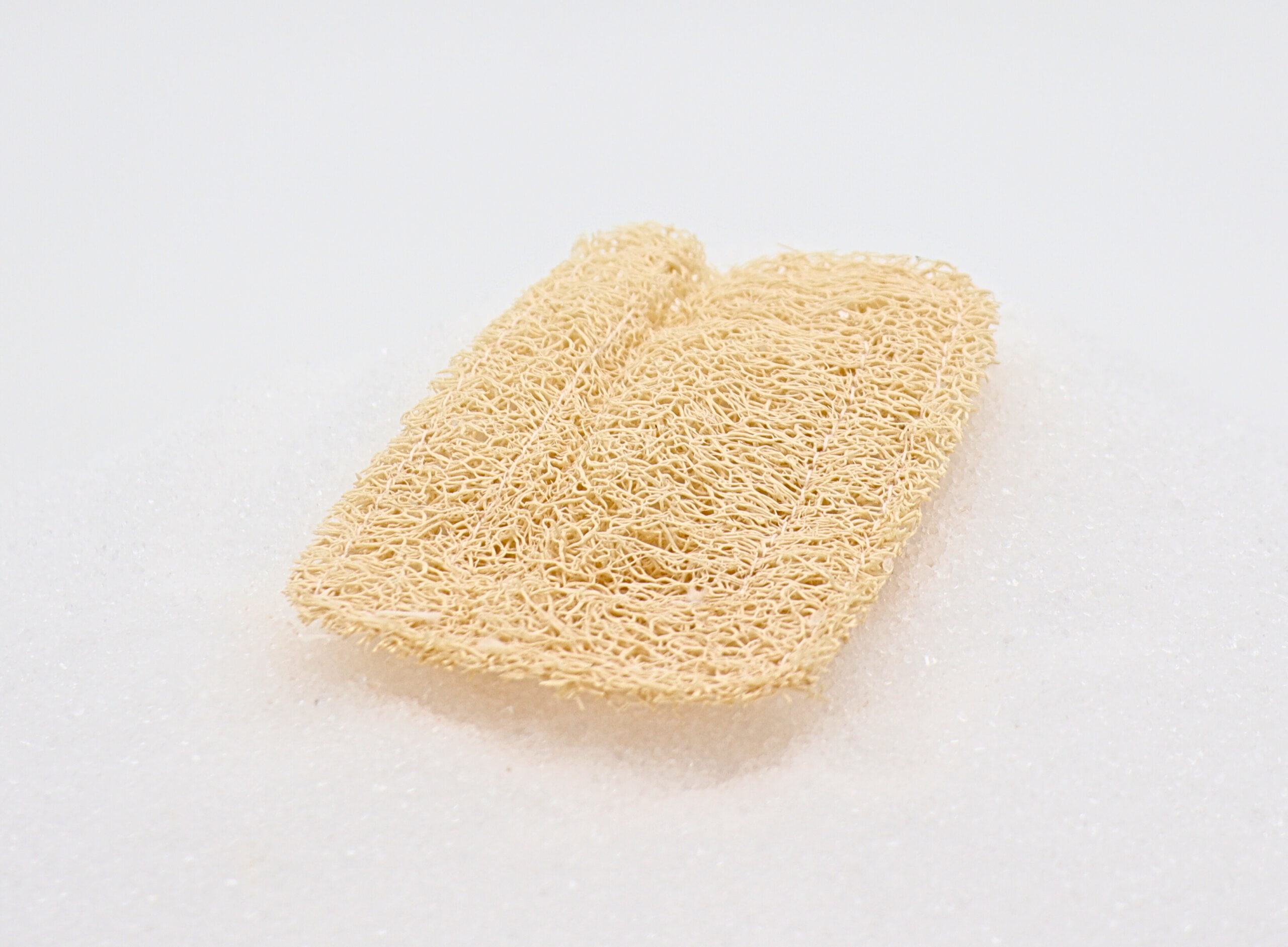 Luffa-Seifenkissen a loofah on a white surface