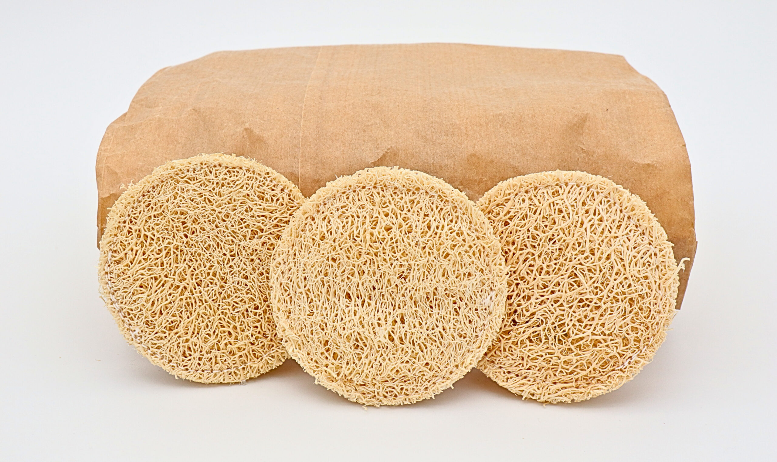 Luffa-Pads im 20er-Pack a brown paper bag with round objects on top of it