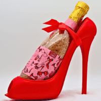 Roter Keramik-Stiletto mit Badesalz enthaltender Sektflasche