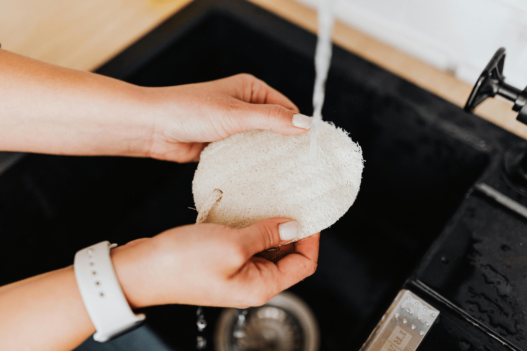 Luffa-Pad Auswaschen eines Luffa-Pads unter laufendem Wasser in Spüle